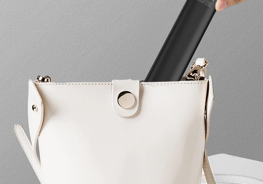 The brush slipped into a white leather handbag